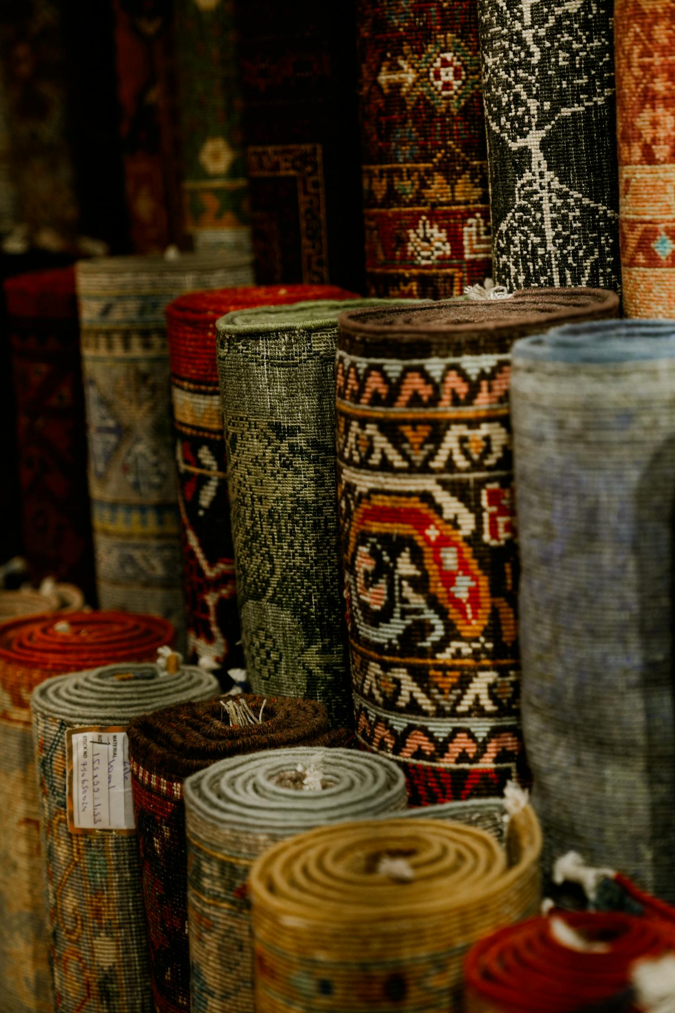 A variety of vibrant rolled-up rugs on display showcasing intricate patterns and textures.